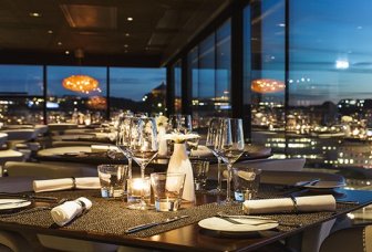 Photo of a restaurant with tables and a view of the city.